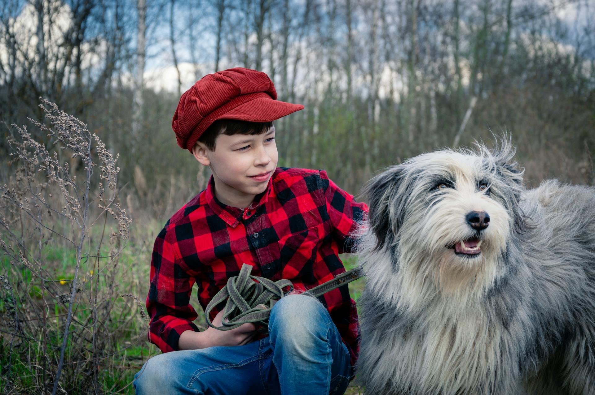 Un garçon avec un vieux chien de berger anglais