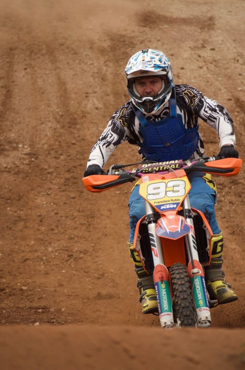 Free Rider on dirt bike racing on sandy track, wearing helmet and protective gear. Stock Photo