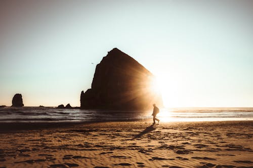 Man strolling on Cannon Beach at sunset