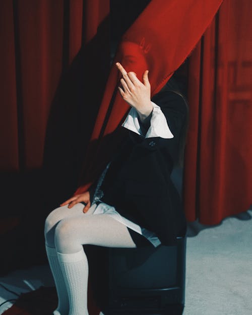 A woman sitting on a chair with her hands covering her face