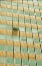 A window in a tall building with a green and yellow pattern