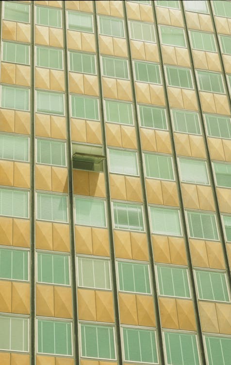 A window in a tall building with a green and yellow pattern