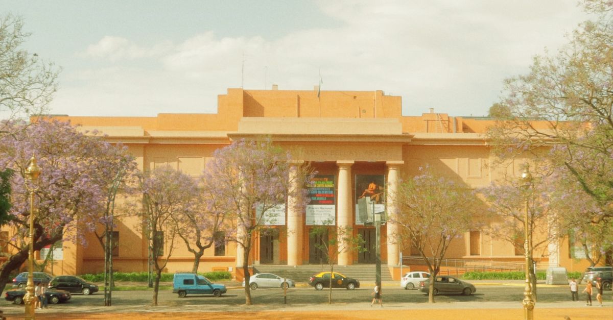Fachada neoclássica do Museu Nacional de Belas Artes em Buenos Aires, cercada por jacarandás floridos