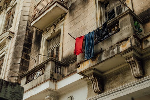 Low angle view of old Havana apartments with clothes drying on the balcony, showcasing urban Cuban architecture.