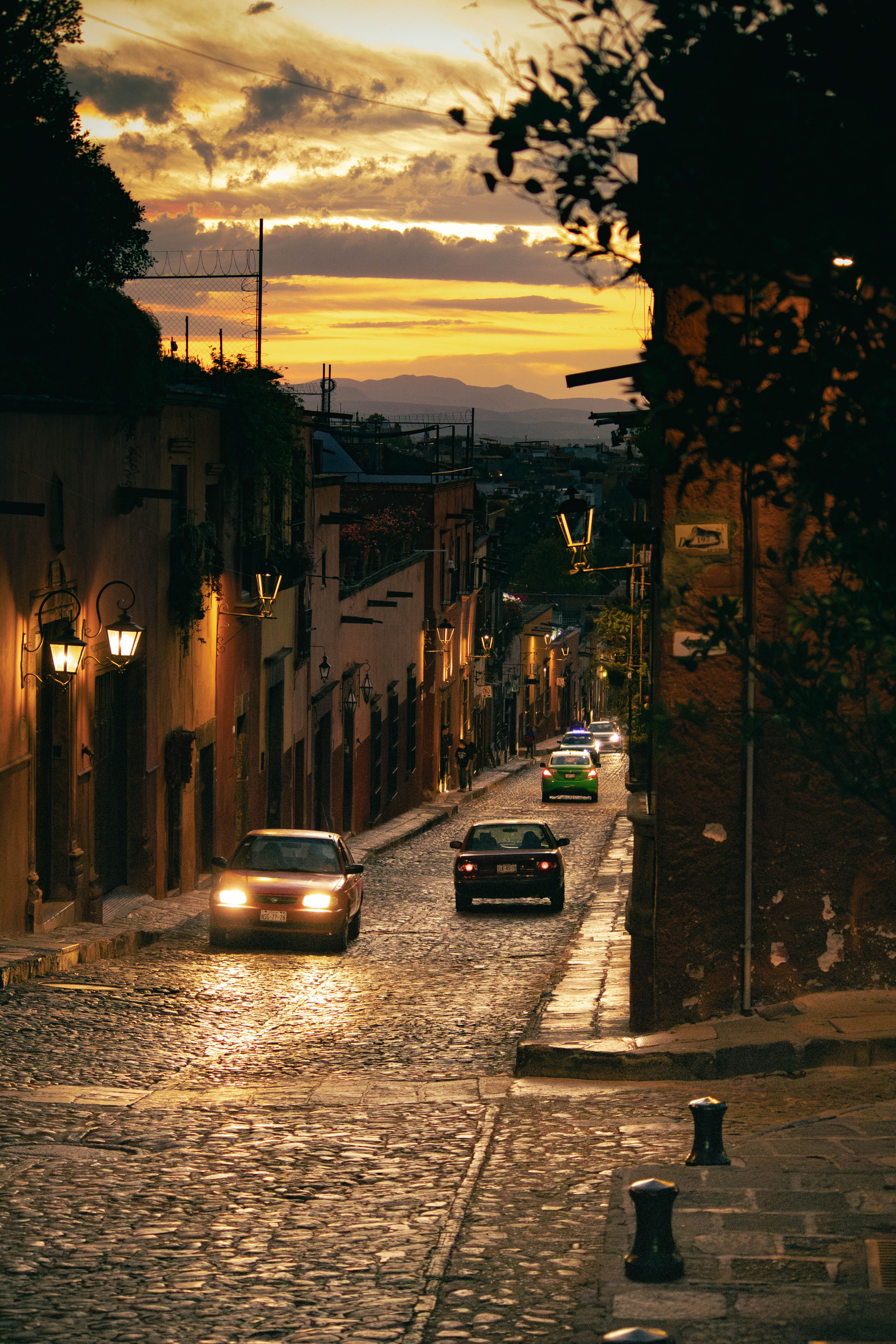 Cars on Cobblestone Street at Sunset · Free Stock Photo