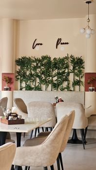 Stylish restaurant interior featuring modern decor, plush seating, and green plant wall.