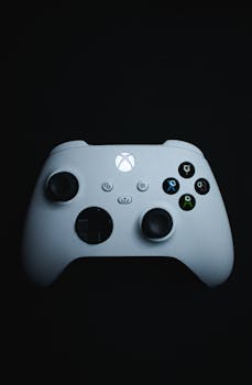 A close-up of an Xbox gaming controller on a black background, highlighting its sleek design.