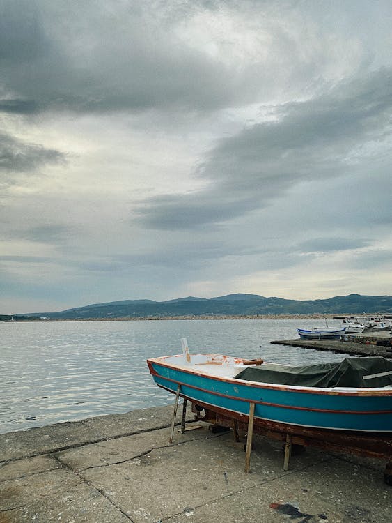 A boat is sitting on the water next to a dock