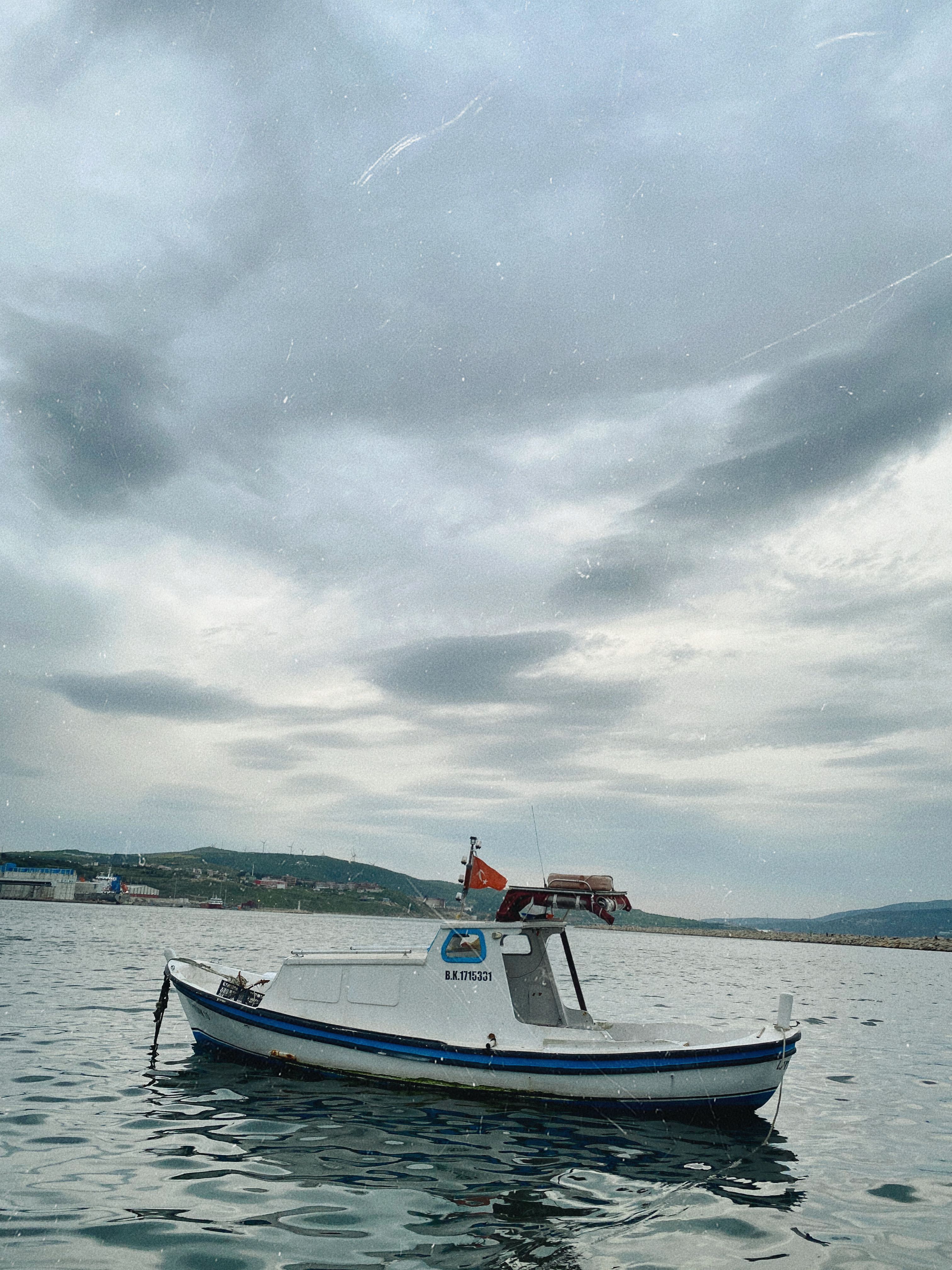 A small boat is sitting on the water · Free Stock Photo