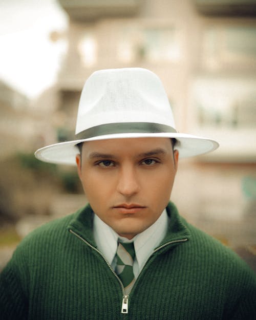 A man wearing a white hat and a green sweater