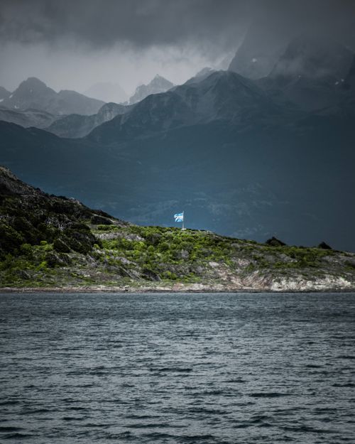 Free Moody view of the rugged mountains and lake in Ushuaia, under overcast skies, showcasing Argentine nature. Stock Photo