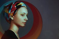 一位女性戴着彩色头巾，优雅的轮廓映衬在抽象背景中