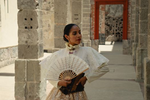 Portrait of a woman in traditional attire, holding a fan in Ciudad de México.