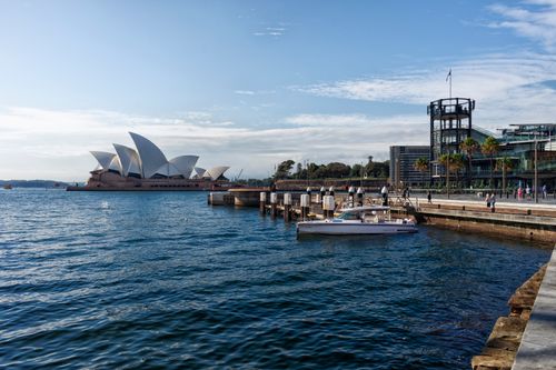 Free Scenic view of the Sydney Opera House and harbor with clear skies and reflections. Stock Photo