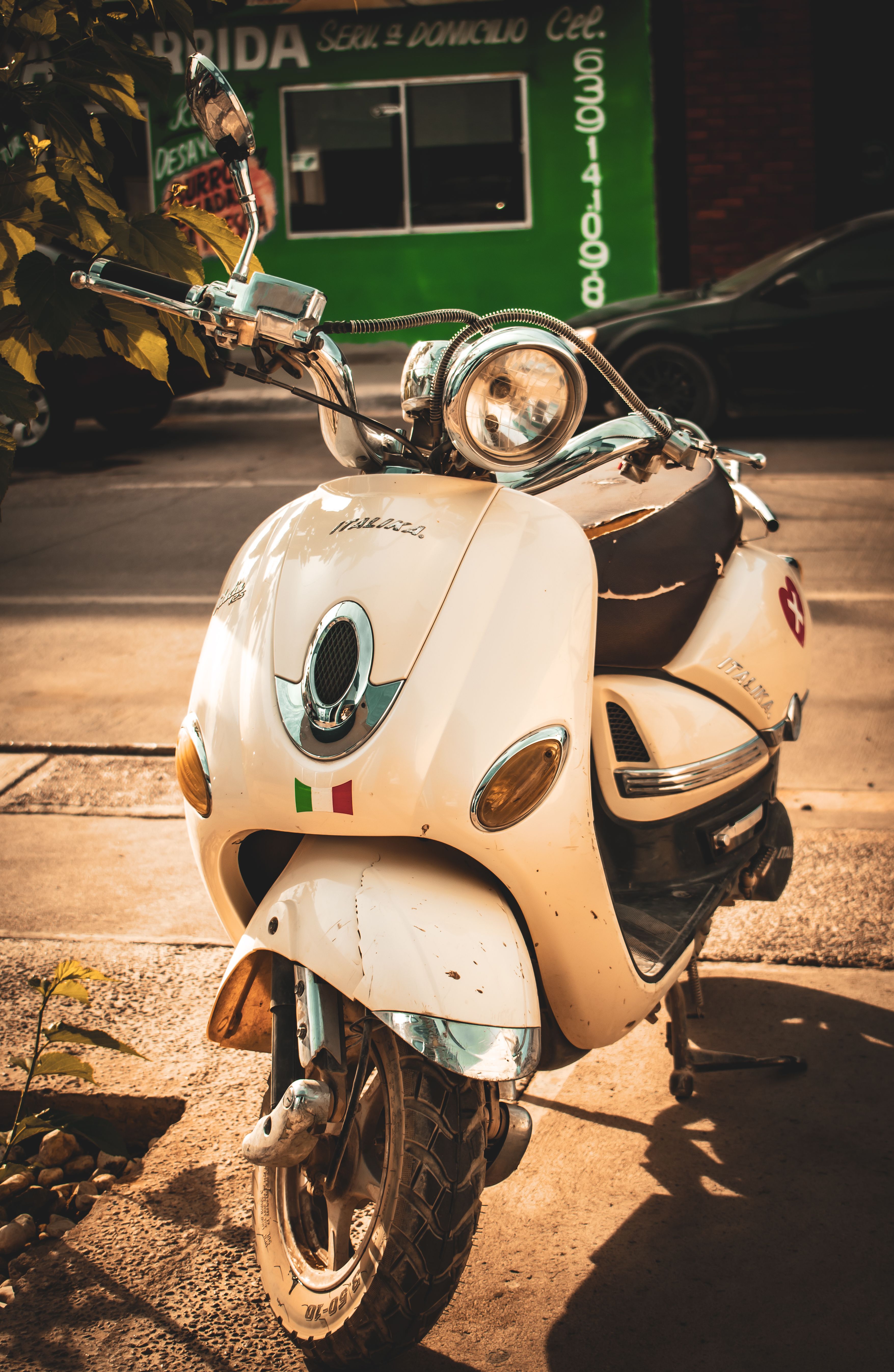 A classic Italika motor scooter parked on a sunlit sidewalk in Pedro Meoqui, Mexico.