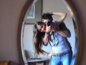 一对情侣在室内对着镜子微笑自拍，记录下快乐的瞬间