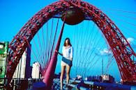 一位时尚女士在莫斯科日沃皮斯尼桥上，以生动的城市背景为衬托摆出姿势