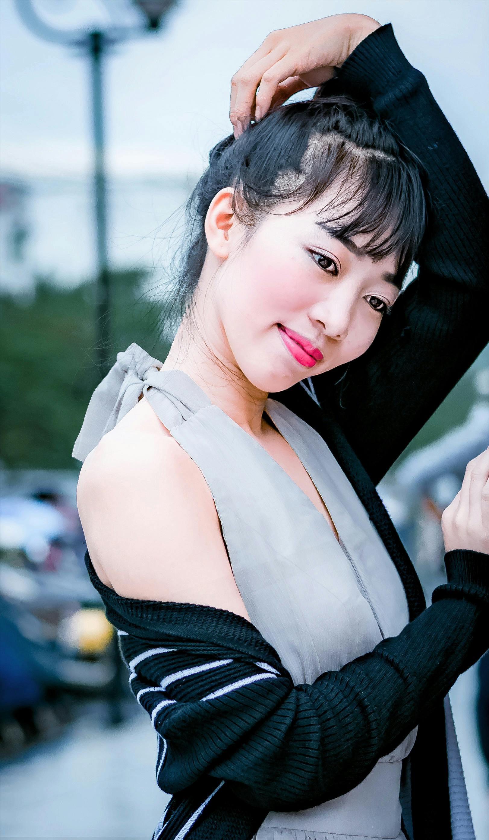 这幅充满活力的户外肖像描绘了一位穿着时尚的年轻女子，她优雅而富有魅力