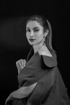 Stylish black and white portrait of a young woman showcasing elegance and fashion.