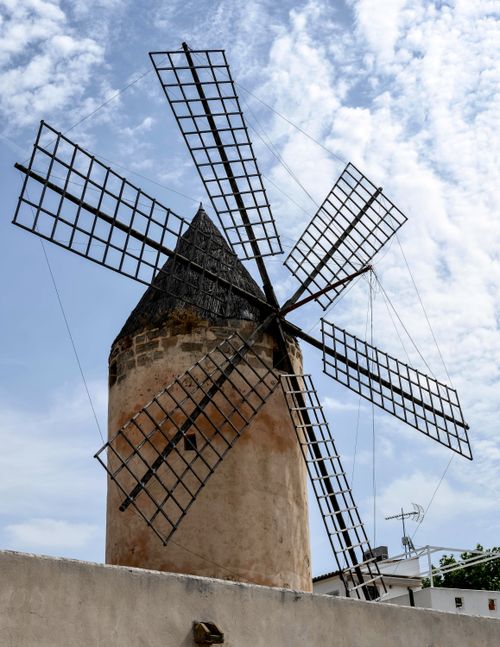 Free Historic windmill with wooden sails in Palma, Spain against a bright sky. Stock Photo