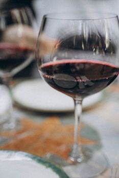 Close-up of a red wine glass set on a dinner table, embodying elegance and sophistication.