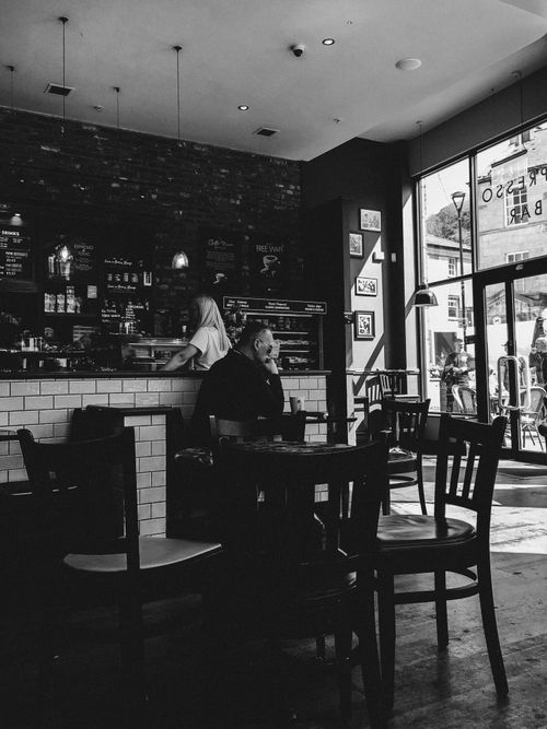 Free Black and white image of a modern café with people enjoying coffee and conversation. Stock Photo