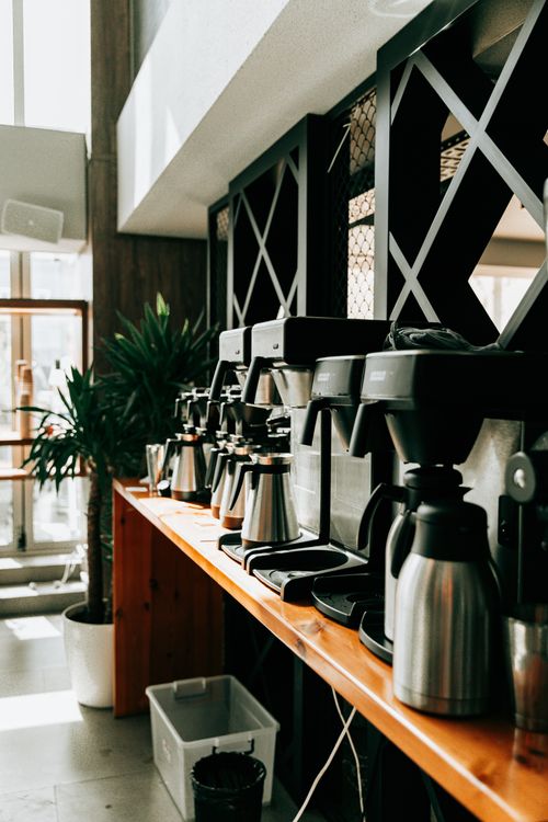 Free A row of coffee machines on a wooden counter in a stylish café. Stock Photo