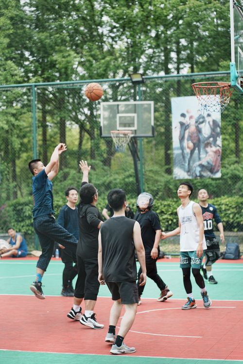 Free Energetic group of young men engaging in a lively basketball game on an outdoor court. Stock Photo