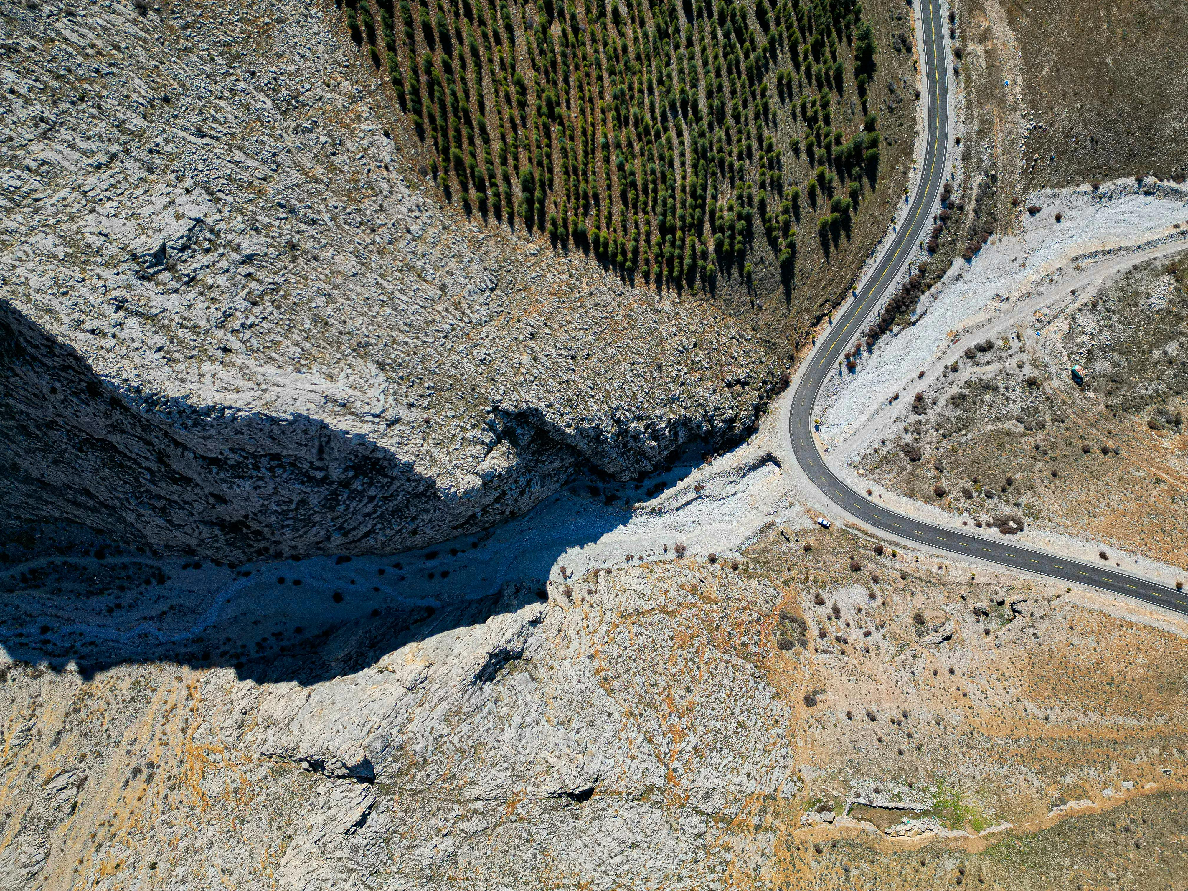 Stunning aerial photograph of a winding road by cliffs and trees in Niğde, Türkiye.