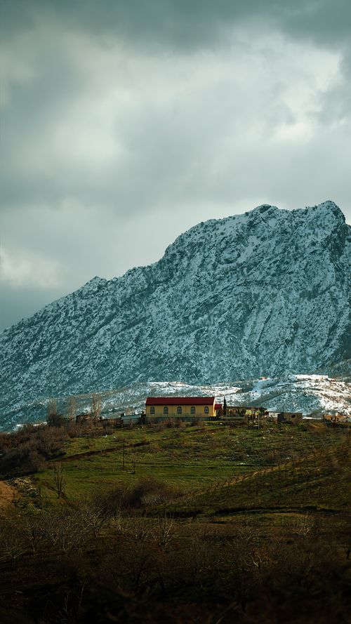 Free Idyllic village setting with a snowcapped mountain in Duhok, Kurdistan Region of Iraq. Stock Photo