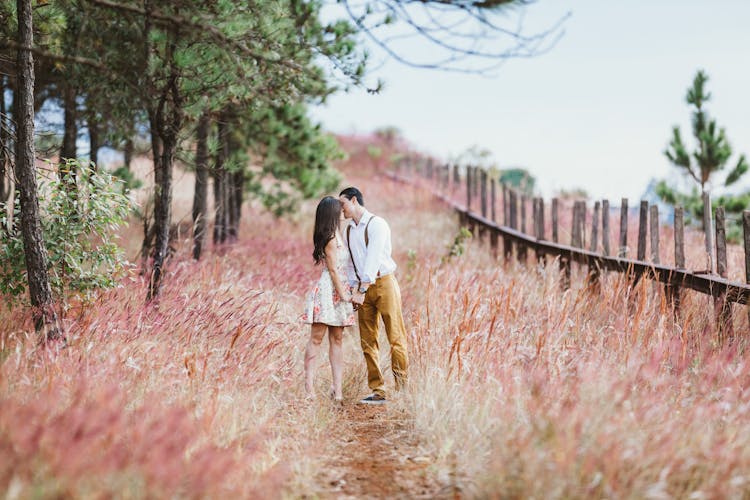 Couple Kissing Beside Trees