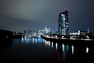 夜晚，法兰克福的灯光天际线倒映在河面上，景色壮丽