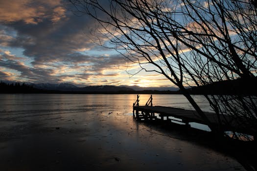 宁静的湖面上，日落静谧，映衬着码头和树木的轮廓