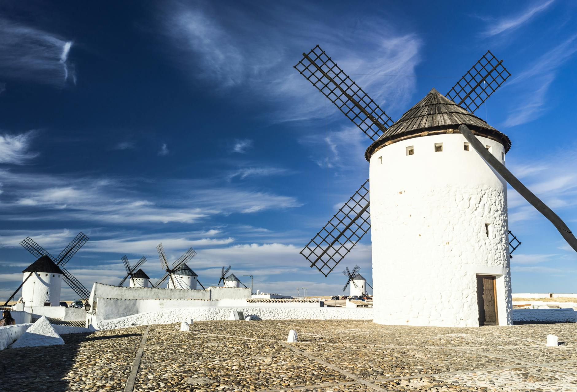 Picturesque scene of traditional Spanish windmills under a blue sky.