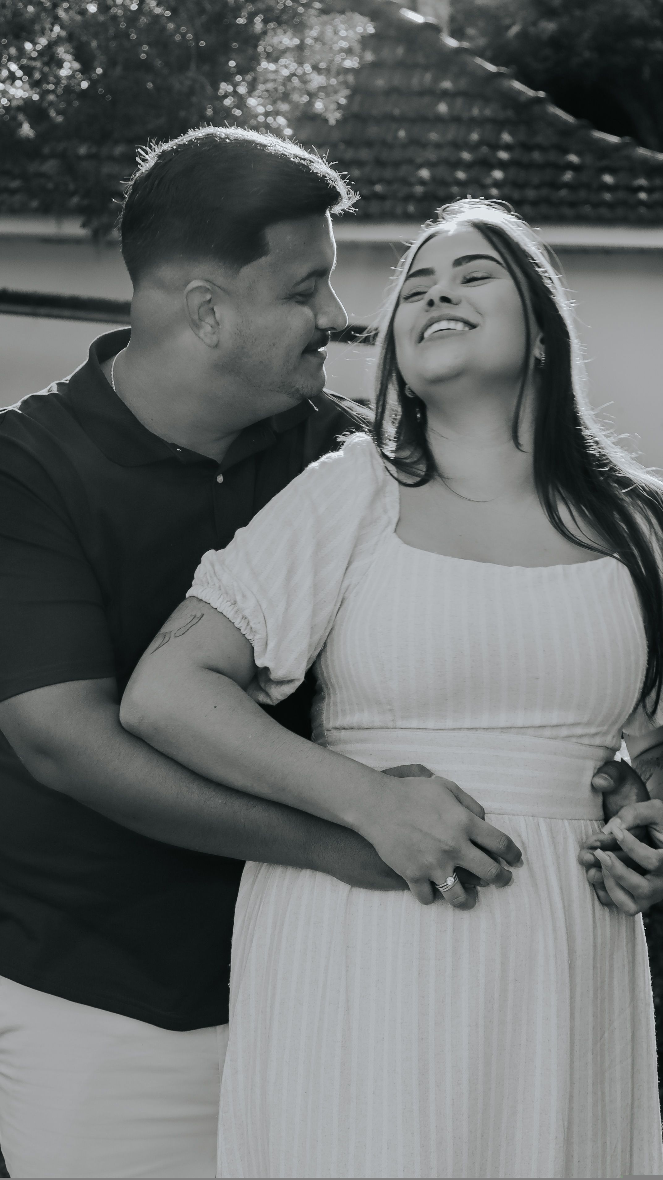 Happy couple embracing outdoors, captured in a warm moment of affection.