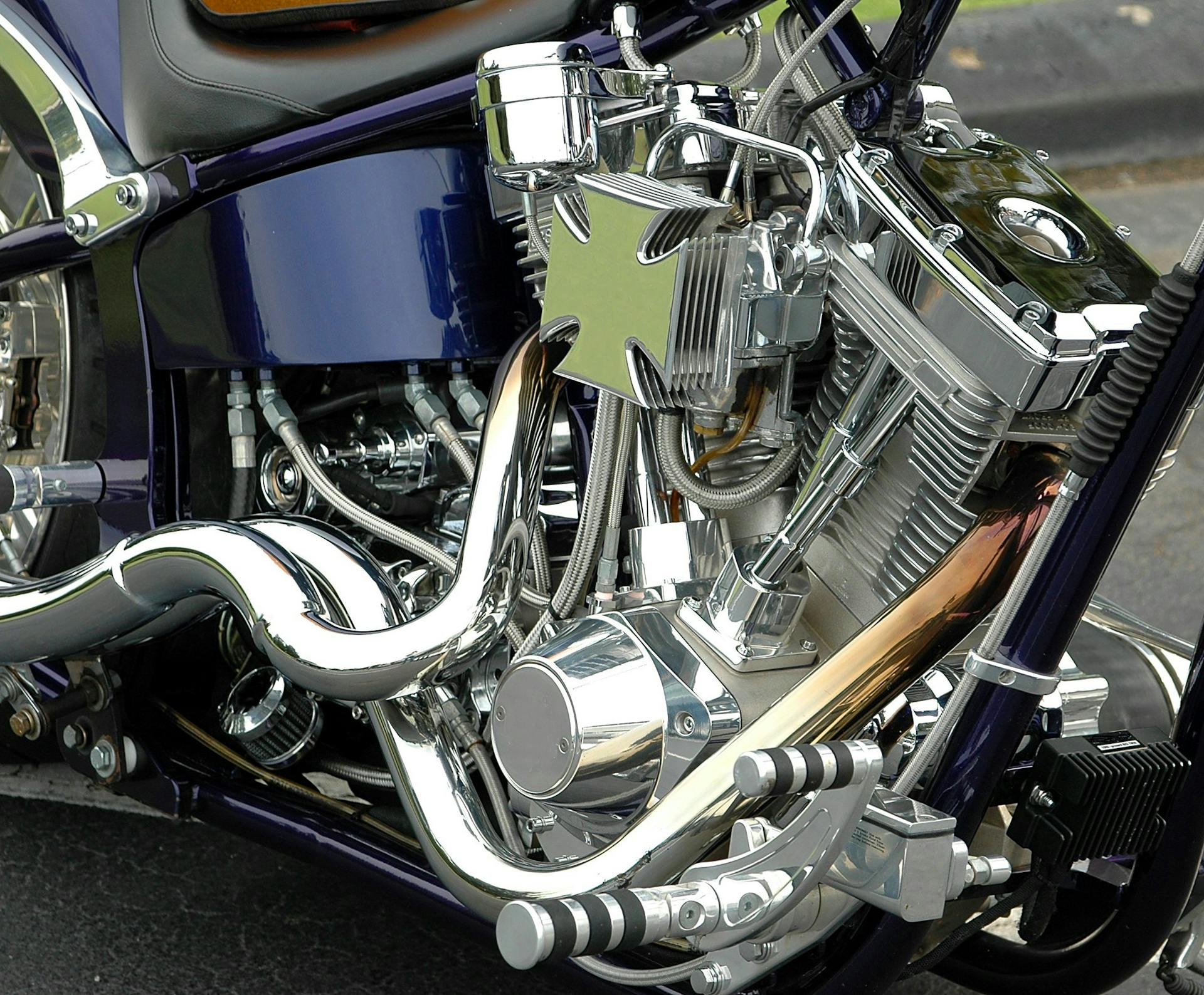 Detailed view of a polished chrome motorcycle engine with a custom cross emblem.