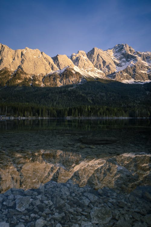 Mountains reflected in a lake with a mountain range in the background