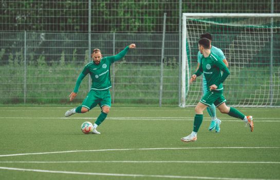 Players in green uniforms engage in a dynamic soccer match on a grassy field.