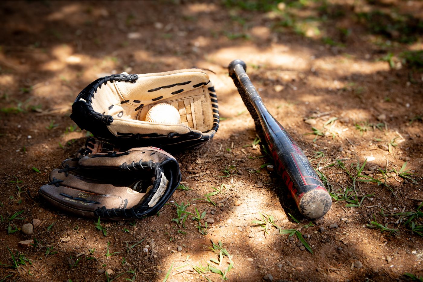 Baseball bat, glove, and ball on a field