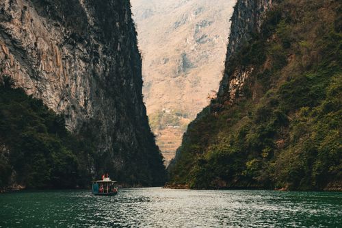 Free Tourboat navigating the stunning Tu San Canyon in Ha Giang, Vietnam, surrounded by towering cliffs. Stock Photo