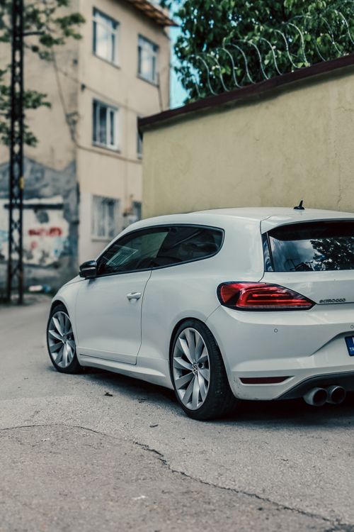 Free A sleek white Volkswagen Scirocco parked on a quiet street in Bursa, Türkiye. Stock Photo
