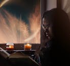 一个女人在烛光下读书，背景宁静而梦幻