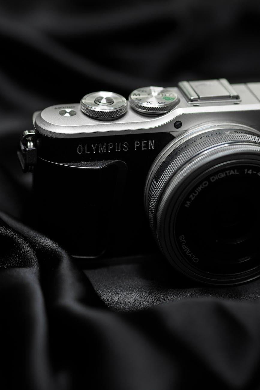 Elegant Olympus Pen camera close-up on a luxurious black satin backdrop.