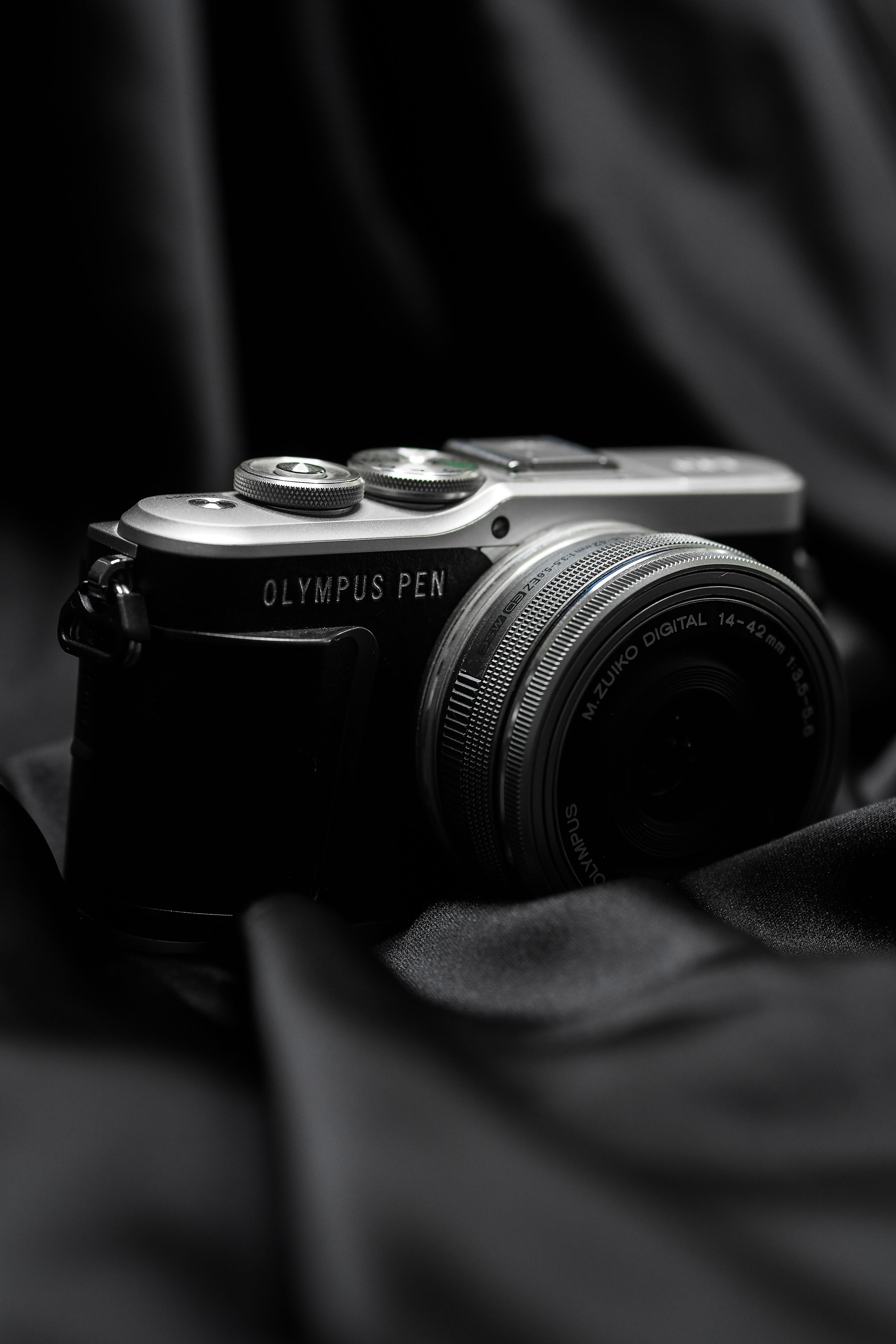 Elegant black-and-white photo of a vintage camera on draped fabric.