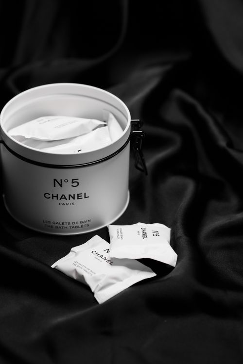 Free Elegant still life of Chanel No. 5 bath tablets on black fabric, showcasing luxury beauty product packaging. Stock Photo