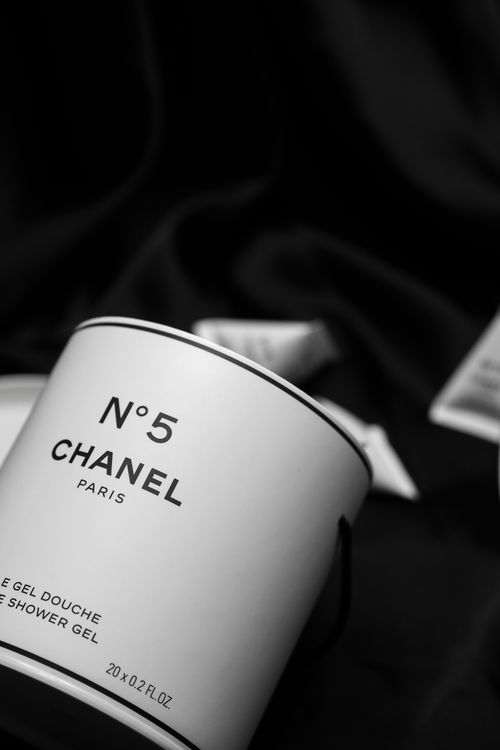 Free Elegant Chanel No. 5 shower gel displayed on luxurious black fabric. Stock Photo