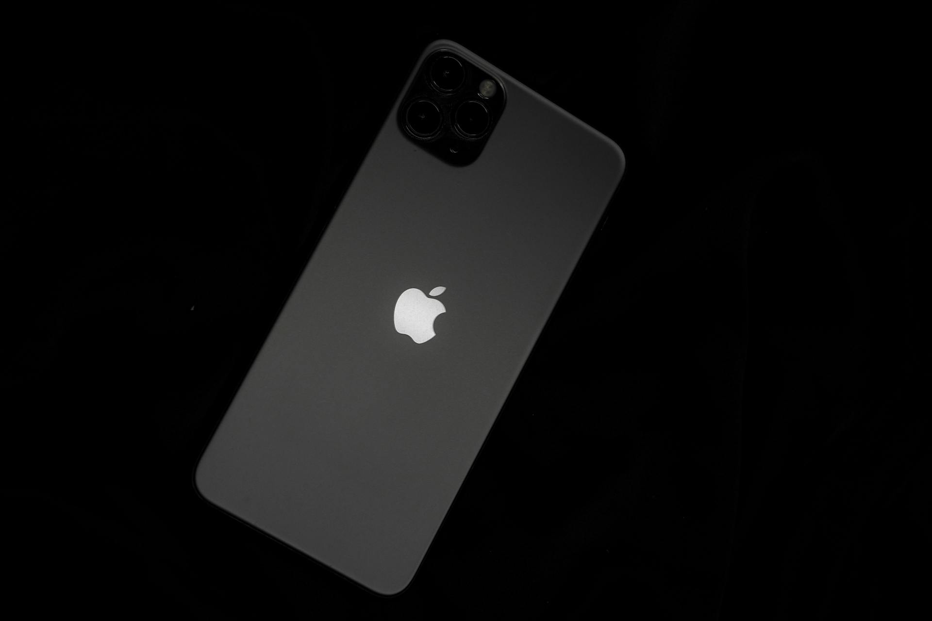 Close-up of a sleek smartphone featuring the iconic Apple logo against a black background.