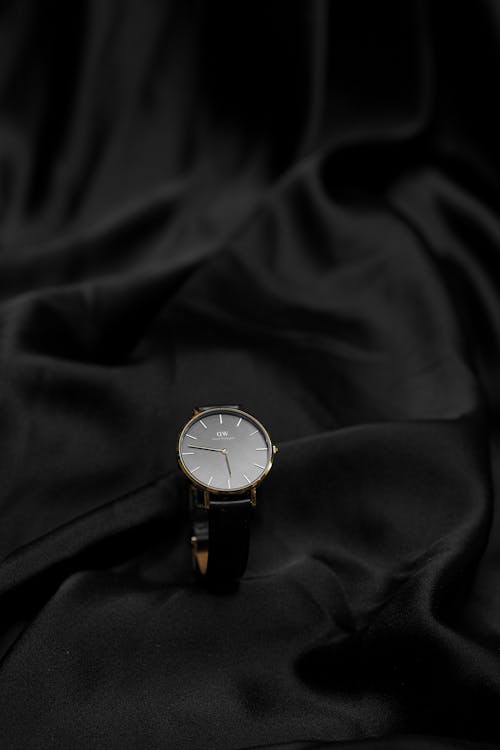 A watch on a black cloth with a white background