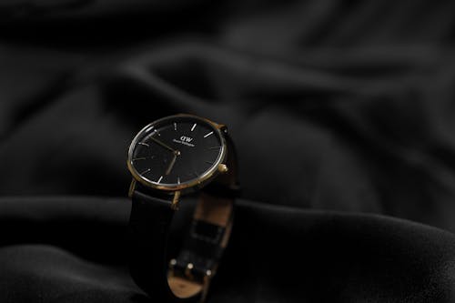 A black and gold watch on a black cloth