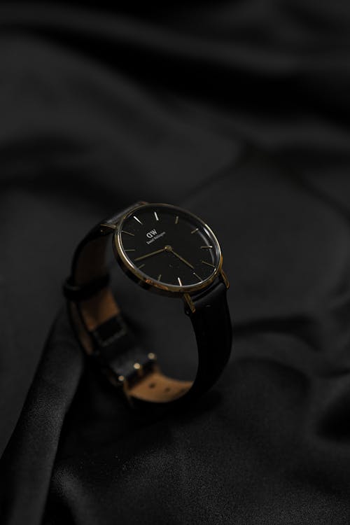 A black and gold watch on a black cloth